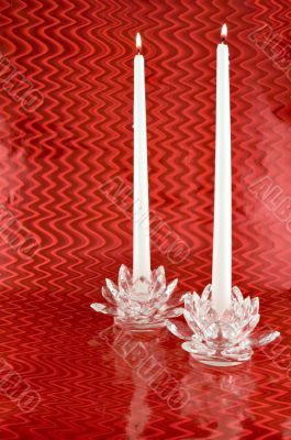 Two White Candles in Crystal Candleholders with Red Backgrounc