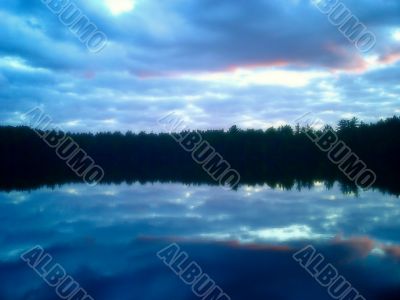 dramatic sunset over placid lake