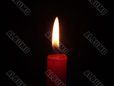 The red candle burning in full darkness