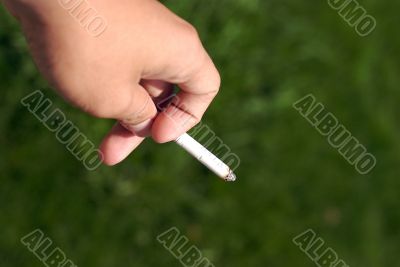 a hand holding a cigarettes