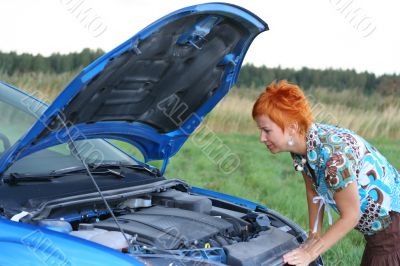 young red-haired woman with her broken car. The girl have a big problem