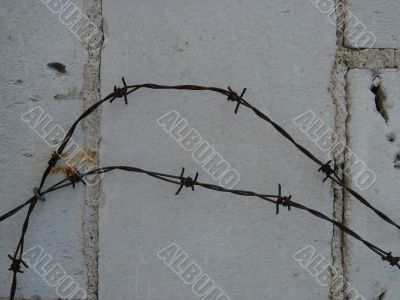 barber wire on the front of brick wall