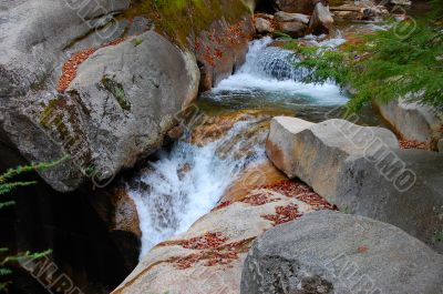 water falls over granite boulders