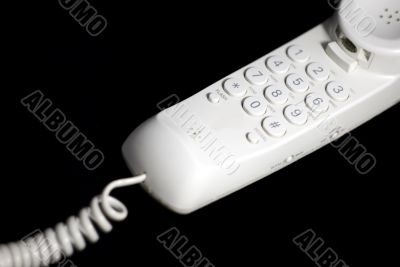 White analog phone on black background