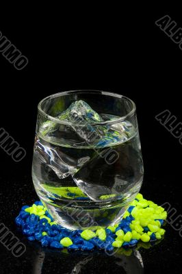 Glass with ice and water on gravel Glass with ice and water on gravel