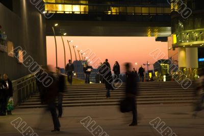 Business people comin and going with red sky