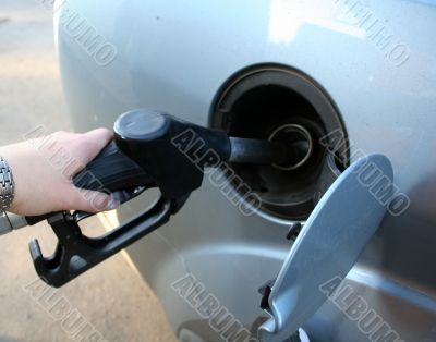 woman filling up auto tank at gas station
