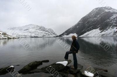 snow mountain with cold lake and young woman