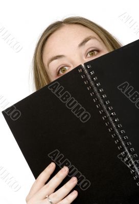 studying peeping over notebook