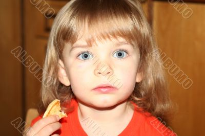 Little pretty blond girl eating pancake
