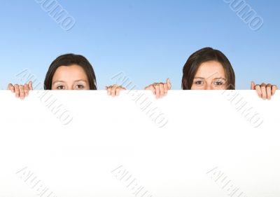 beautiful twins holding a white board
