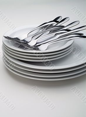 Silverware on a stack on white plates