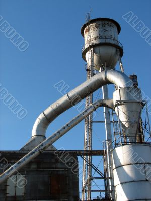 Factory building with water tower and metal pipes