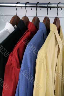 Colorful shirts on wooden hangers