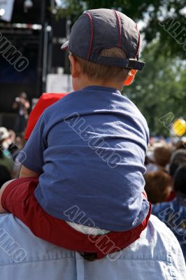 Boy sitting on the shoulders of his father