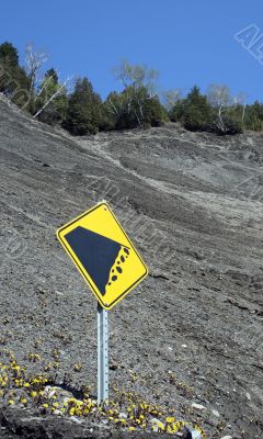 Falling rocks sign on the mountain slope