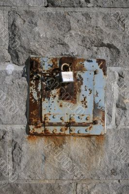 Iron lock and rusty chain on a stone wall