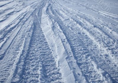 Car tracks crossing the snowy terrain
