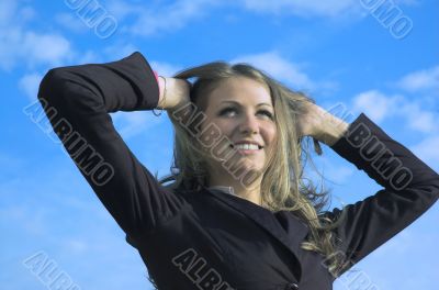 The happy girl on a background of the blue sky