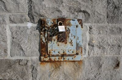 Iron lock and rusty chain on a stone wall