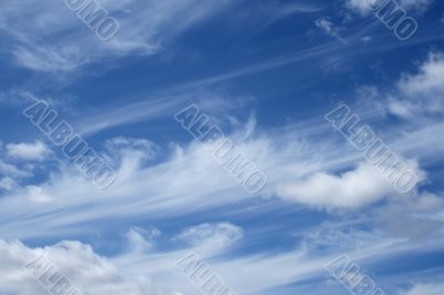 Curly white clouds in the blue sky