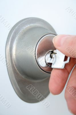 Hand unlocking the door with a key Hand unlocking the door with a key