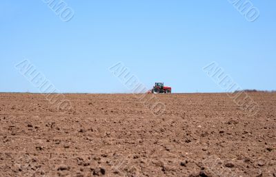 Tractor in a spring field plowing land