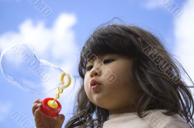 Little girl making bubbles