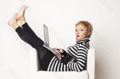 Nice blondgirl sitting on the chair with laptop