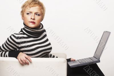 Nice blondgirl sitting on the chair with laptop