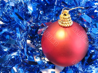 Red christmas ball on blue glare Red christmas ball on blue glare