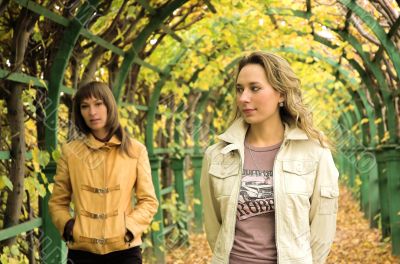 Two girls having a rest in autumn park