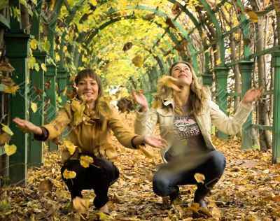 Two girls having a rest in autumn park