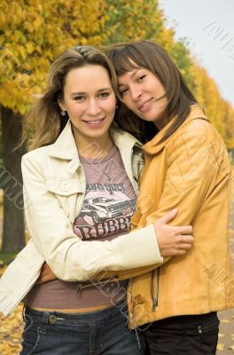 Two girls having a rest in autumn park