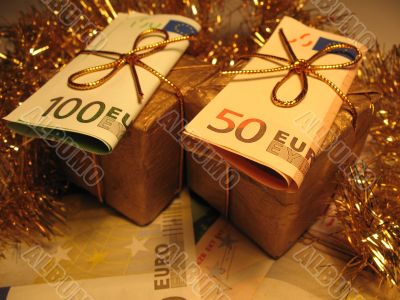 Two golden christmas gift boxes with money
