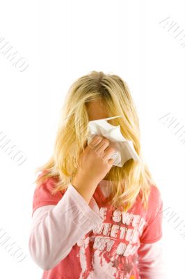 Young blond girl sneezing in the handkerchief