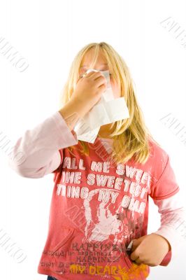 Young blond girl sneezing in the handkerchief