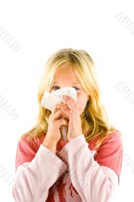 Young blond girl sneezing in the handkerchief