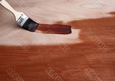 Painting a wooden surface with a brush