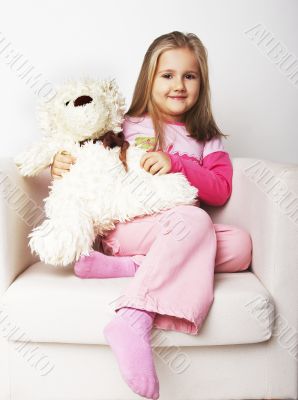 Nice young girl in pink on light background with teddy bear