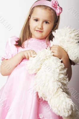 Nice young girl in pink on light background with teddy bear