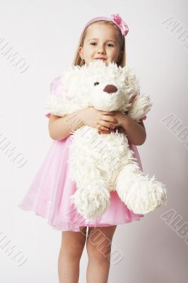 Nice young girl in pink on light background with teddy bear