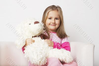 Nice young girl in pink on light background with teddy bear