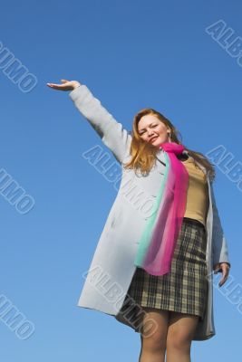 The happy girl on a background of the blue sky