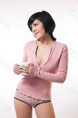 The girl in pink linen with a cup in hands