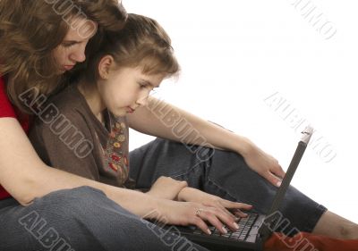 Mother with daughter work at computer