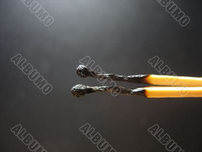 The burned down matches on a dark grey background