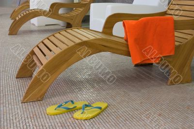 sunbed with towel  and yellow sandals near from left