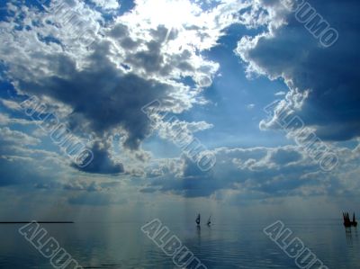 The sky and the sun in clouds above a gulf