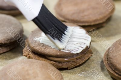 brushing frosting on cookies
